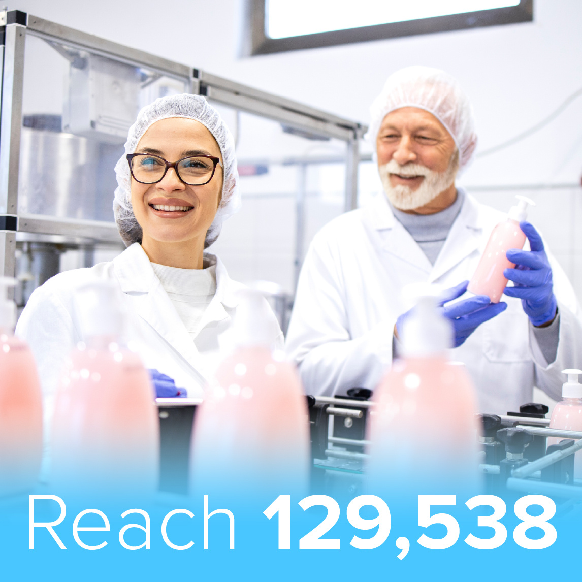 Two personal care product manufacturers wearing white lab coats, hairnets, and gloves inspect pink bottled products on a production line. One smiles at the camera while the other evaluates the bottles. The background features industrial manufacturing equipment. A blue banner at the bottom displays the text 