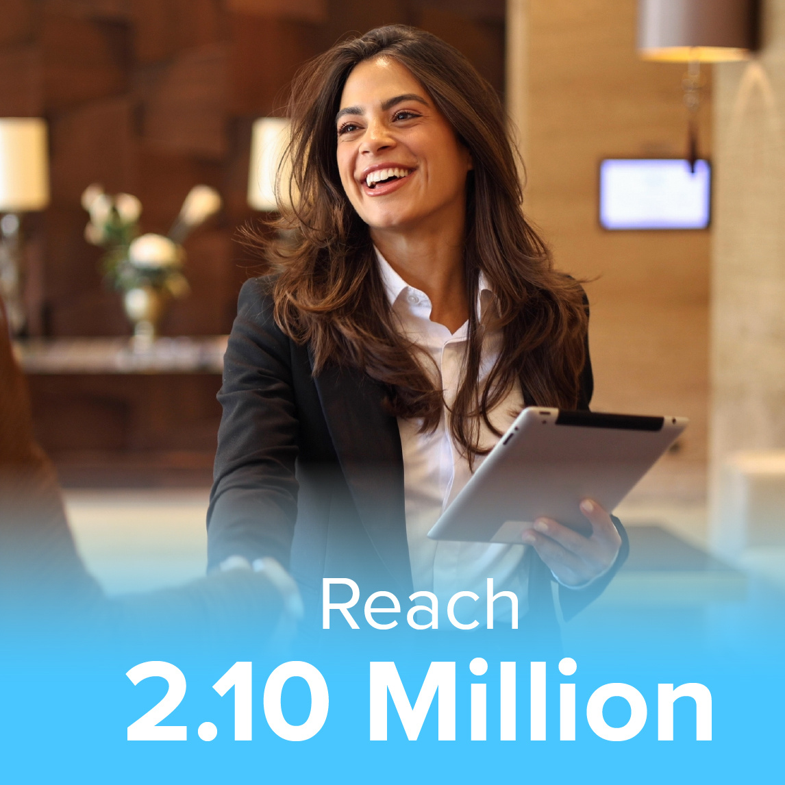 A smiling hospitality professional in a business suit holding a tablet, extending a handshake in a welcoming hotel lobby. The image includes a text overlay that reads 