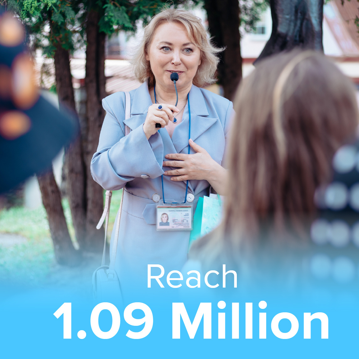 A cheerful tour guide wearing a headset microphone speaks to a group of travelers in an outdoor setting. The image includes a text overlay that reads 